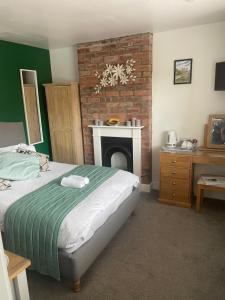 a bedroom with a bed and a brick fireplace at Camaraderie Guest House in York