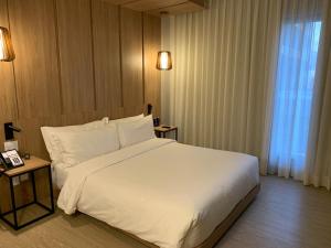 a bedroom with a large white bed and a window at Radisson Pinheiros in São Paulo