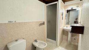 a white bathroom with a toilet and a sink at Les Chambres de Giottani in Barrettali