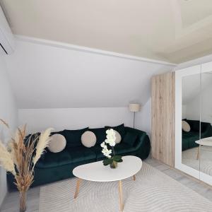 a living room with a green couch and a table at Cozy SoRaDa 3 apartment in Bragadiru