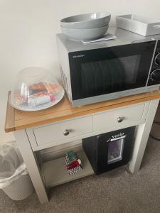 a microwave sitting on top of a table with a plate at Camaraderie Guest House in York