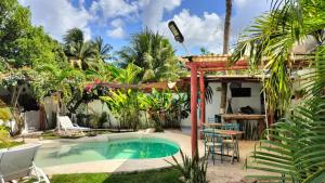a swimming pool in a yard with a table and chairs at teki-sha home&suites in Bacalar