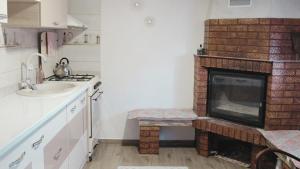 a kitchen with a fireplace and a sink at Mary's Country House in Luncaviţa