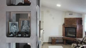 a living room with a fireplace and pictures on the wall at Mary's Country House in Luncaviţa +21 photos