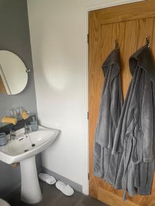 a bathroom with a sink and towels hanging on a door at Camaraderie Guest House in York