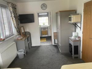 a room with a kitchen with a clock on the wall at Camaraderie Guest House in York
