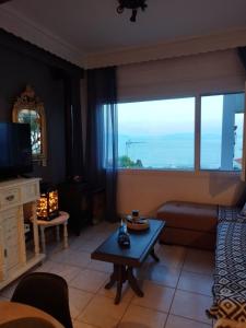 a living room with a couch and a table and a window at Mare Mia in Loutraki +35 photos