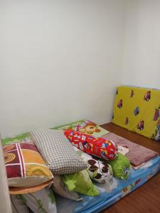 a bed with colorful pillows on it in a room at Villa gunung mas c6 in Berastagi