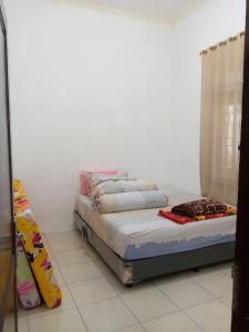 a bed sitting in a room with a window at Villa gunung mas c6 in Berastagi