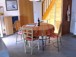 a dining room table with chairs and a bottle of wine on it at Mas de Perimont 28 in Fleury