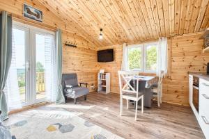 a room with wooden walls and a table and a chair at Chalet de campagne en Dordogne in Thénac