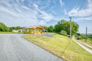 a small yellow house on the side of a road at Chalet de campagne en Dordogne in Thénac