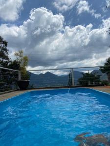 a large blue swimming pool with a view of mountains at casa aconchegante com linda vista a 5 min do centro in Nova Friburgo