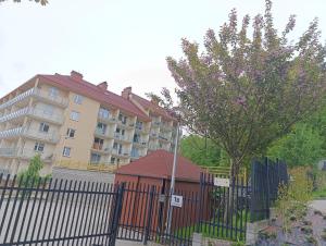 a building in front of a fence with a house at LECH Home APARTAMENT NA GÓRZE in Wisła