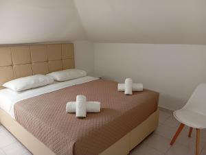 a bedroom with a bed with two towels on it at Apartments Gregory & George in Hanioti