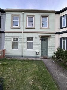 una casa con una puerta verde y un patio en Cheerful 5 Bedroom House Close to Central West End and Parking, en Glasgow