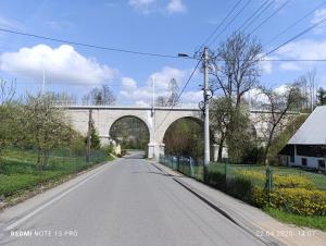 an empty road with a bridge in the background at LECH Home APARTAMENT NA GÓRZE in Wisła