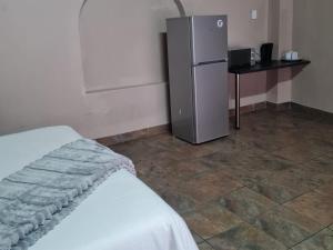 a room with a small refrigerator and a table at Shabi's Guest Lodge in Phalaborwa