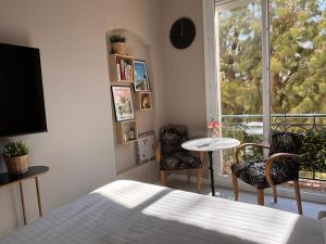 a bedroom with a bed and a table and chairs at Boulevard de la croisette PALAIS MIRAMAR in Cannes