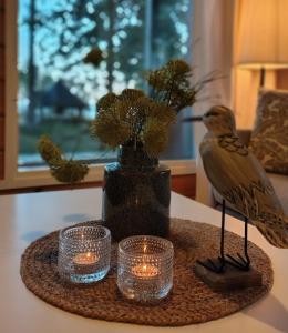 a bird sitting on a table with candles and a vase at Villa Dyyni - Oulujärvi Manamansalo in Vaala