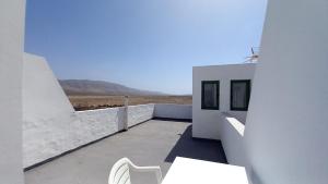 un edificio bianco con un tavolo e una sedia bianca di Uviya 2 a Famara