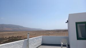 un edificio bianco con una sedia appoggiata su un balcone di Uviya 2 a Famara