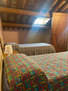 a bedroom with two beds with a colorful comforter at Il Belvedere sul Conero in Potenza Picena