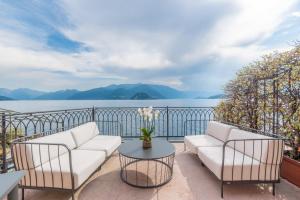 a balcony with two white couches and a table at Casa Du Lac, by R Collection Hotels in Varenna