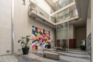 a lobby with a colorful mural on the wall at Departamento un ambiente Premium Puerto Norte Rosario in Rosario