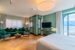 a hotel room with a bed and a couch and a tv at Casa Du Lac, by R Collection Hotels in Varenna +63 photos
