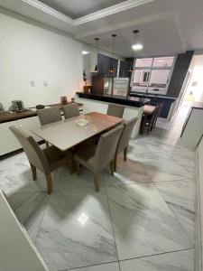 una sala da pranzo e una cucina con tavolo e sedie di The Brown beach House a Rio Grande