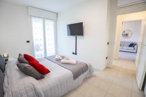 a bedroom with a bed with red pillows and a television at Le Ninfee in Zola Predosa