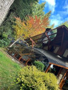 a building with a glass roof with trees in the background at Casa Del Bosque Aparts in Villa La Angostura