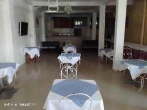 a room with tables and chairs and a kitchen at Hotel Lile John in Bonamakolo
