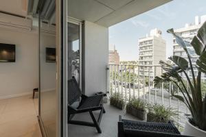 a room with a balcony with a chair and plants at Departamento un ambiente Premium Puerto Norte Rosario in Rosario