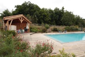 a swimming pool with a gazebo next to at Gite rural de Bergnes à l'ombre des grands pins in Campagne-sur-Aude