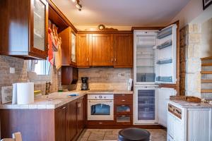 a kitchen with wooden cabinets and a refrigerator at Emily's Luxury Suites in Pefkochori