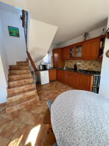 a kitchen with stairs and a table in a room at Hegy és Balaton Vendégház in Badacsonytördemic