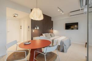 a room with a table and a bed and a table and chairs at Departamento un ambiente Premium Puerto Norte Rosario in Rosario +35 photos