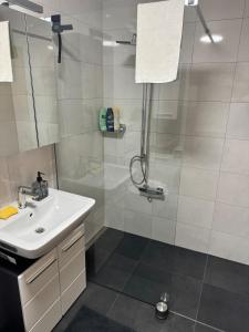 a white bathroom with a shower and a sink at Komplett neu renovierte Wohnung! in Hannover +3 photos