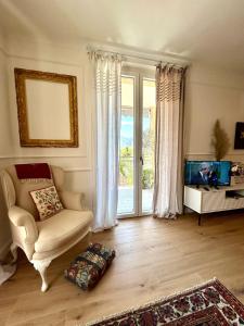 a living room with a couch and a tv and a window at Lake Como Retreat,AC,pool,EV car in Bellagio