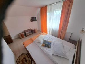 a bedroom with a bed and a window at Casa Doi Crai in Zărneşti