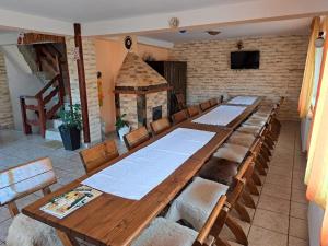 a long wooden table in a room with a fireplace at Casa Doi Crai in Zărneşti