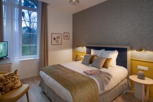a bedroom with a large bed and a window at DOMITYS - Cœur de Loire in Tours