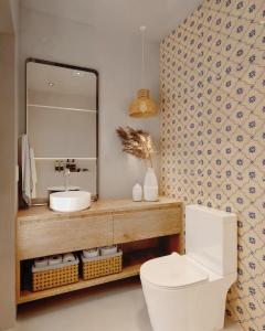 a bathroom with a sink and a mirror and a toilet at Fátima's Place - Cozy Loft in Old Town Viana in Viana do Castelo