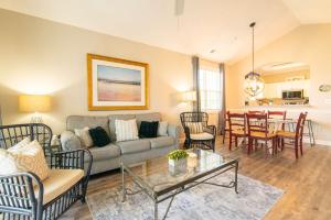a living room with a couch and a table at Massive Waterfront Pool Lakefront Condo Famous Barefoot Resort in North Myrtle Beach