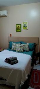 a bedroom with a large bed with blue pillows at Casa Vintage in Joinville