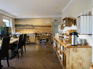 a restaurant with a table and chairs and a kitchen at Hotel Mein Bergblick in Hahnenklee-Bockswiese