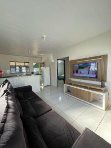 ein Wohnzimmer mit Sofa und Flachbildfernseher in der Unterkunft Sua casa em Dourados in Dourados