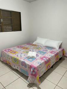 ein Bett in einem Zimmer mit zwei Telefonen darauf in der Unterkunft Sua casa em Dourados in Dourados